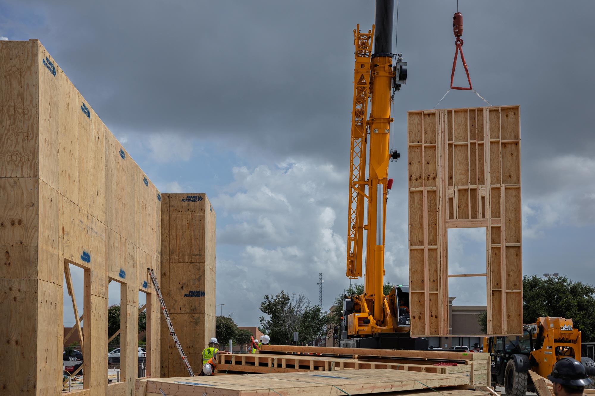 Prefabricated wall panel lifted into place by crane